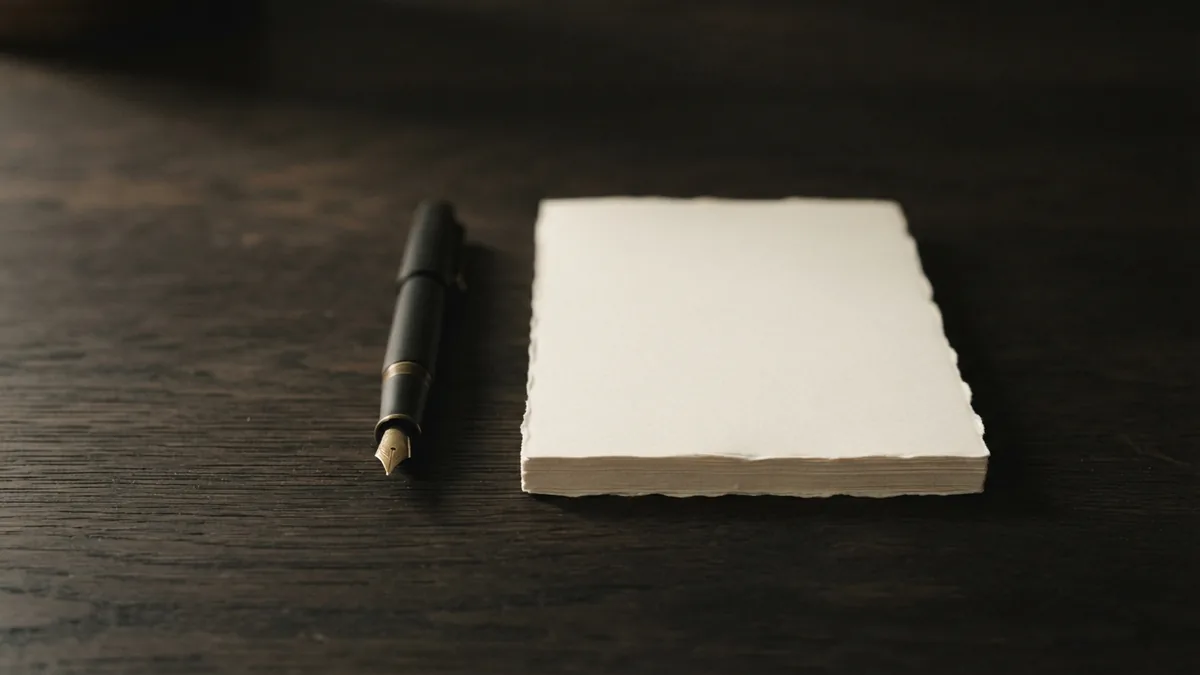 Fountain pen beside blank sheets, suggesting the planning and review duties of a manager