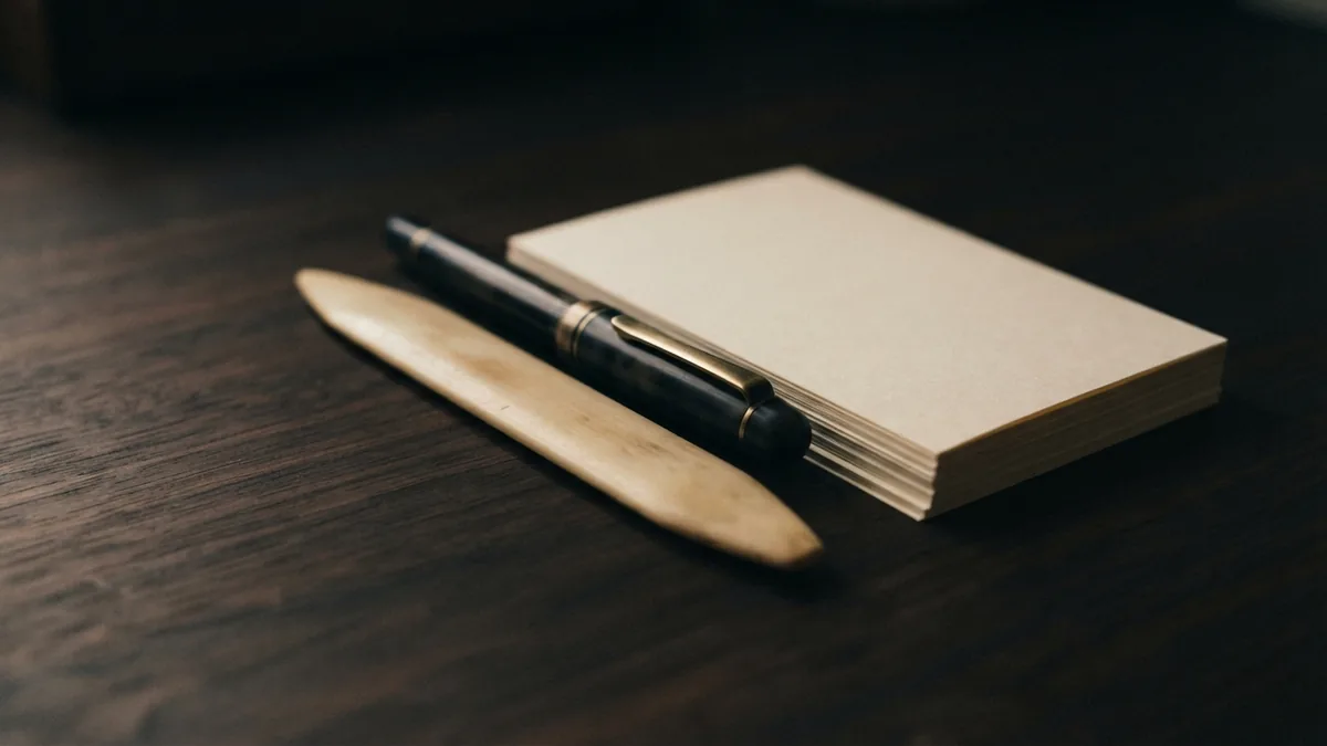 Blank planning papers and brass stationery arranged for a lawn care business plan