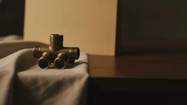 A brass manifold splitting one inlet into four outlets, resting on folded linen beside a closed folder